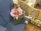child cuddling dolls