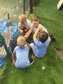 children playing on grass at fence with toys