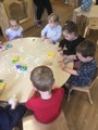 Children at table with plastic shapes and play doh