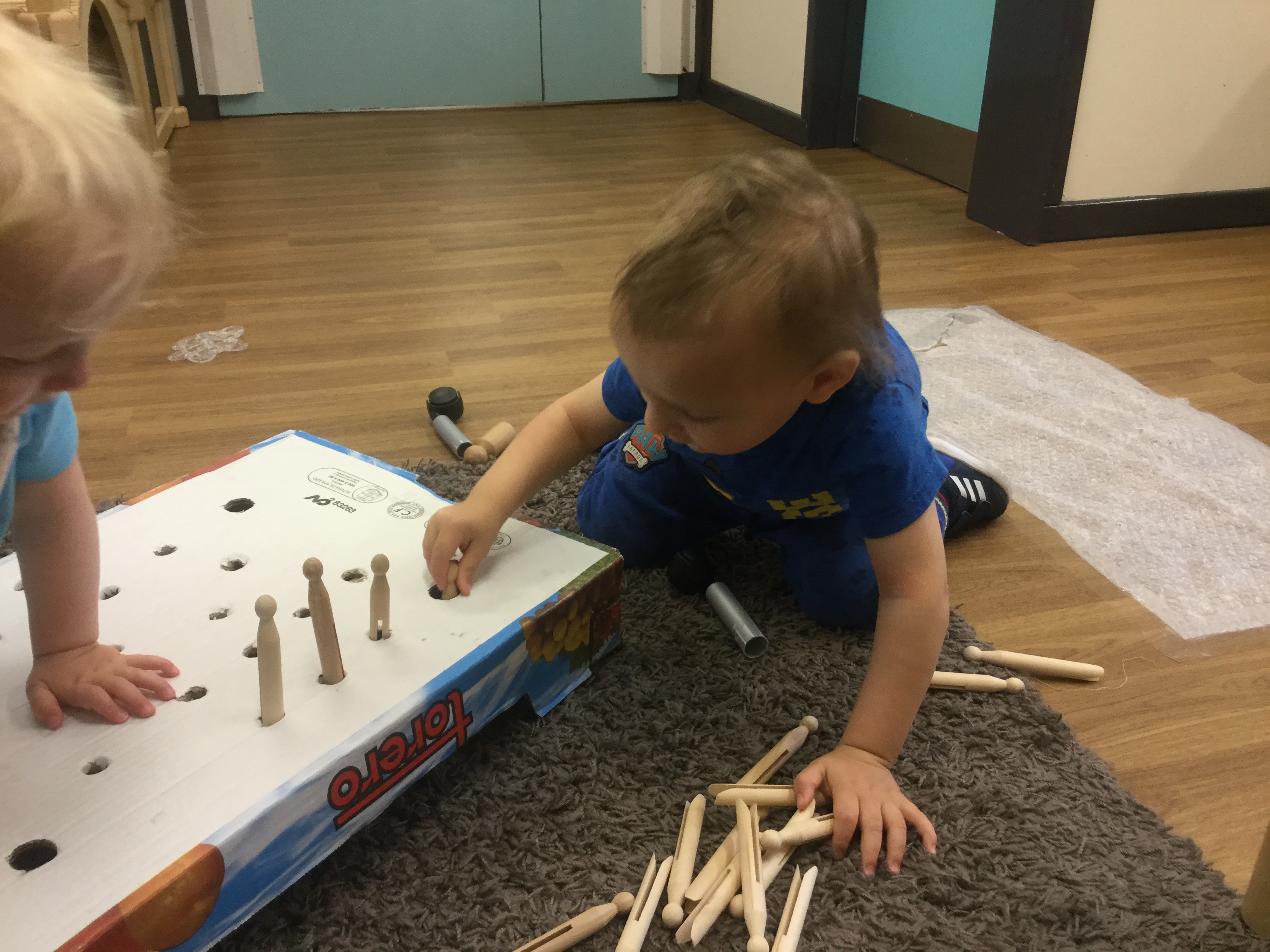 children putting pegs into peg board