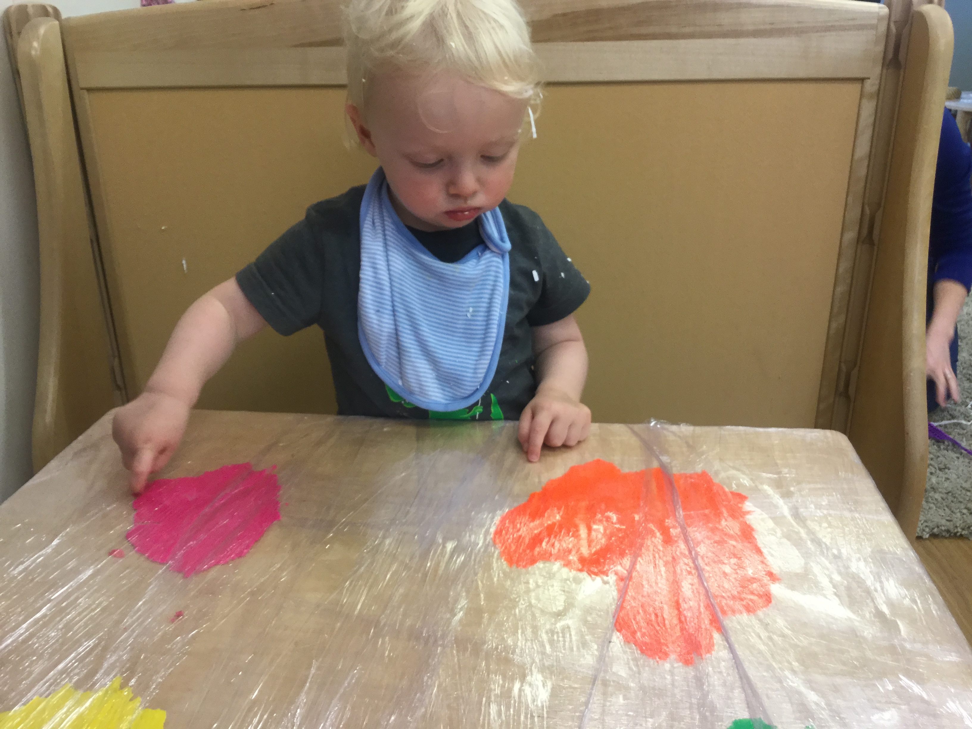 child at table finger painting