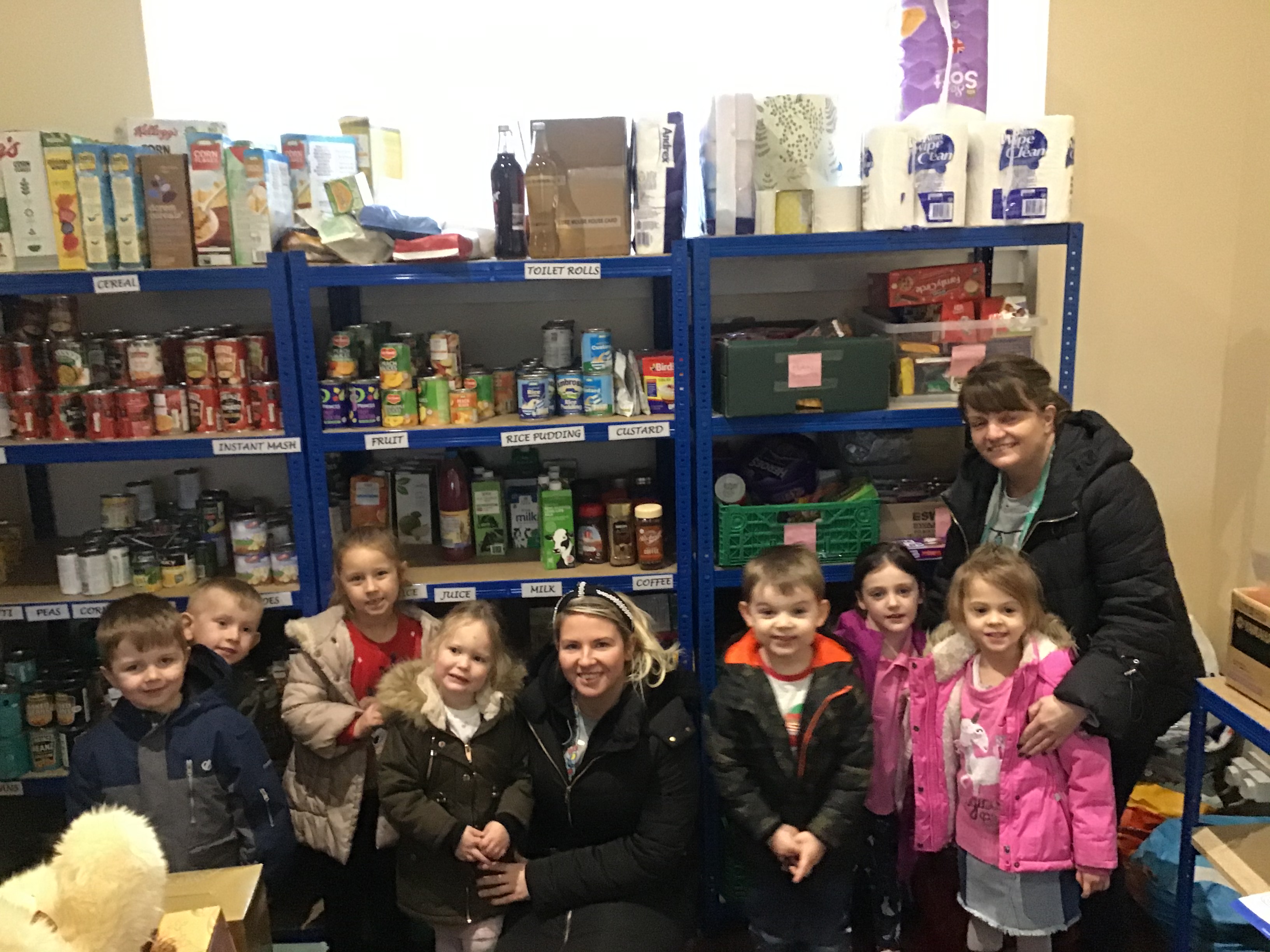 CHILDREN IN FRONT OF FOOD ON SHELVES